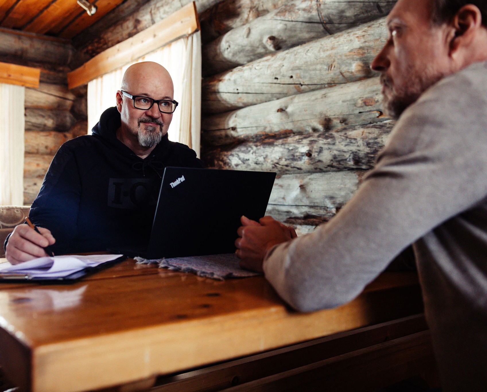 Mökkivuokrauksen suunnittelua asiakkaan kanssa pöydän ääressä.